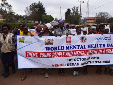 crowd of people carry a large sign